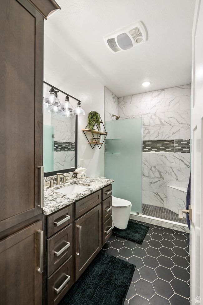 Bathroom with a shower stall, vanity, tile patterned flooring, and recessed lighting | Image 80