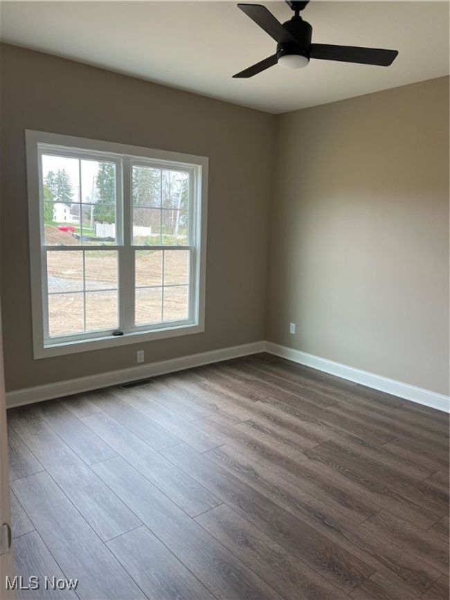 Unfurnished room featuring dark wood-style flooring and ceiling fan | Image 14