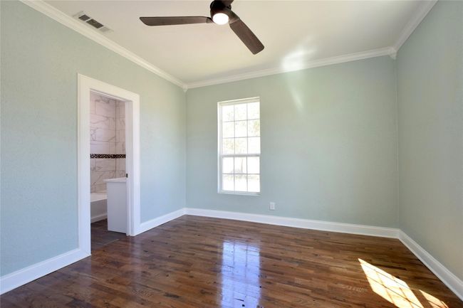 Spare room featuring ornamental molding, ceiling fan, and dark wood-style flooring | Image 12