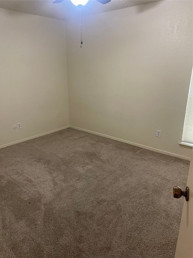 Empty room with a ceiling fan and carpet | Image 13