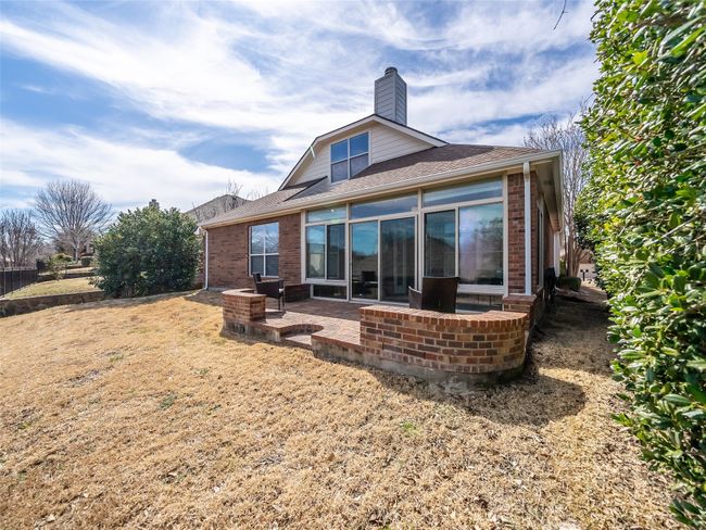 Back of house featuring a patio area, a shingled roof, a chimney, and brick siding | Image 29