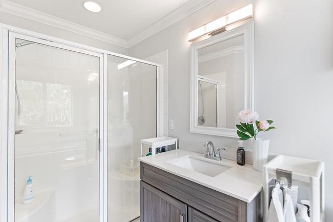Full bathroom with vanity, a shower stall, and ornamental molding | Image 15