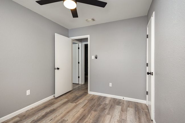 Unfurnished bedroom with wood finished floors, baseboards, and a ceiling fan | Image 34