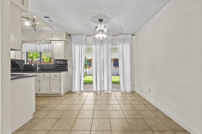 The dining area is conveniently located between the kitchen and living spaces, making mealtimes and entertaining easy. | Image 15