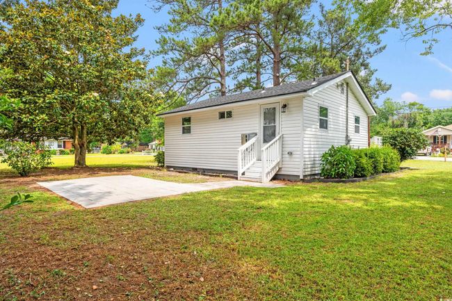 Rear view of house with entry steps, a yard, and a patio area | Image 16