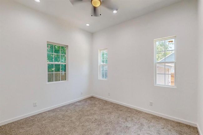 Empty room featuring ceiling fan, a healthy amount of sunlight, and carpet floors | Image 18