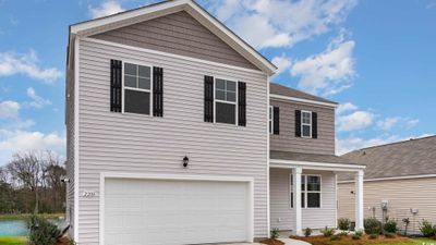 View of property featuring a garage, cooling unit, and a front lawn | Image 1