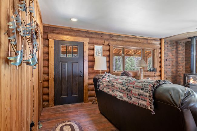 Foyer with log walls, wood finished floors, a wood stove, and recessed lighting | Image 31