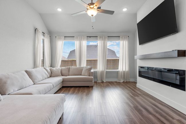 Living room featuring wood finished floors, vaulted ceiling, a ceiling fan, and recessed lighting | Image 11