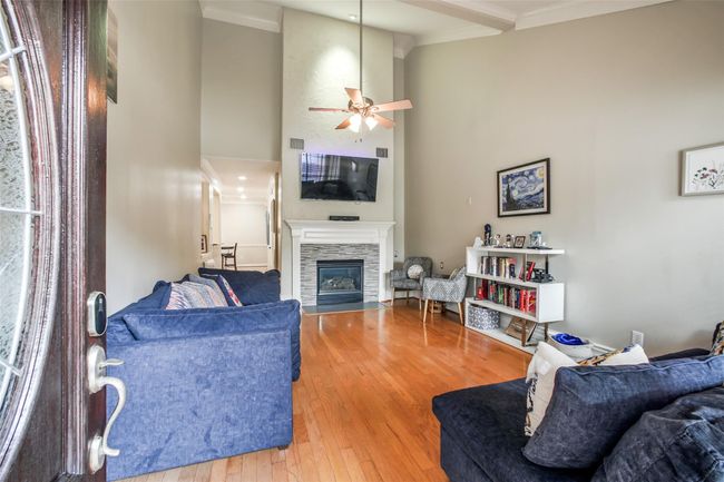 High ceilings & a fireplace are featured in this spacious living area. | Image 5