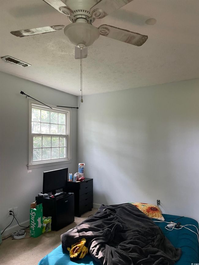 Bedroom featuring light carpet, ceiling fan, and a textured ceiling | Image 34