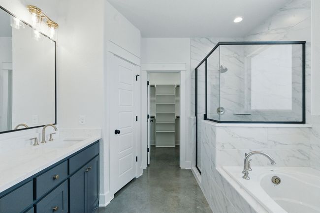 Full bath featuring a marble finish shower, a garden tub, vanity, a spacious closet, and recessed lighting | Image 12
