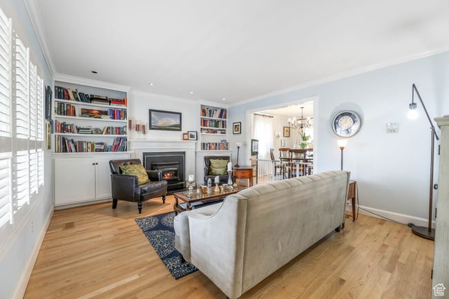 Living room with ornamental molding, light wood-type flooring, and a healthy amount of sunlight | Image 4