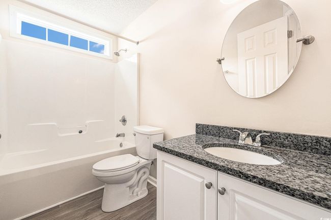 Full bath featuring shower / tub combination, vanity, wood finished floors, and a textured ceiling | Image 29