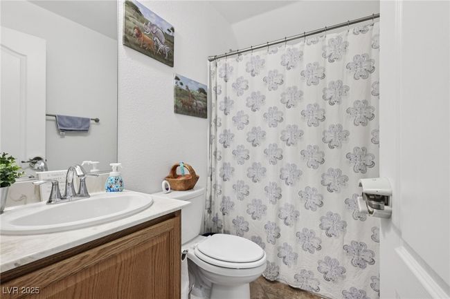 Full bathroom with vanity, toilet, and a shower with shower curtain | Image 34