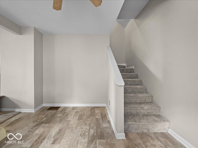 staircase with wood finished floors and a ceiling fan | Image 6