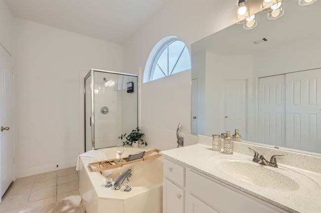 Full bathroom with a bath, vanity, a shower stall, and tile patterned floors | Image 17