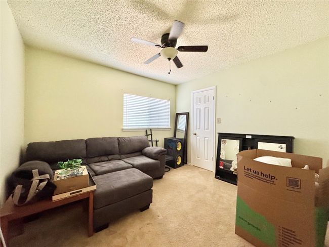 Living room featuring a ceiling fan, a textured ceiling, and carpet flooring | Image 11