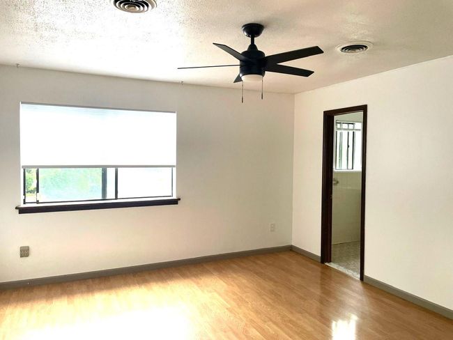 Unfurnished room featuring light wood-type flooring, ceiling fan, and a textured ceiling | Image 9