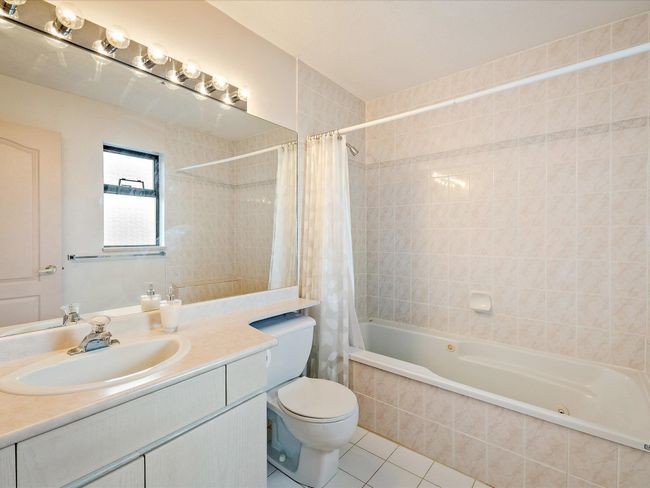 Full bath with tiled shower / bath combo, vanity, toilet, and tile patterned floors | Image 18