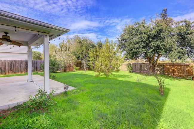 Fenced backyard featuring ceiling fan and a patio | Image 19
