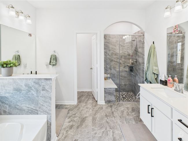 Bathroom with a stall shower, vanity, a bath, marble finish floors, and baseboards | Image 23