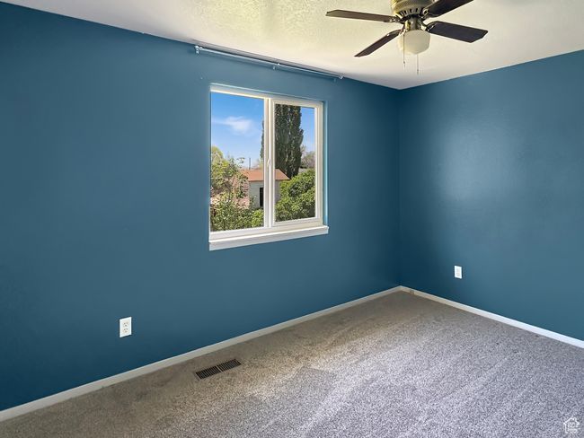 Spare room featuring ceiling fan, carpet floors, a textured ceiling, and baseboards | Image 16