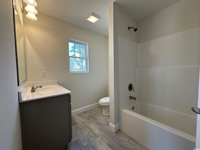 Bathroom featuring vanity, bathing tub / shower combination, toilet, and baseboards | Image 22