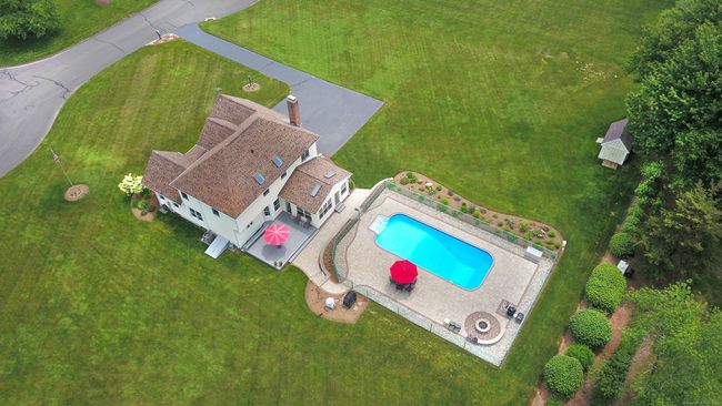 Backyard is a beautiful oasis with spacious composite decking and pristine in-ground pool with paver surround and fire pit with sitting wall. | Image 4