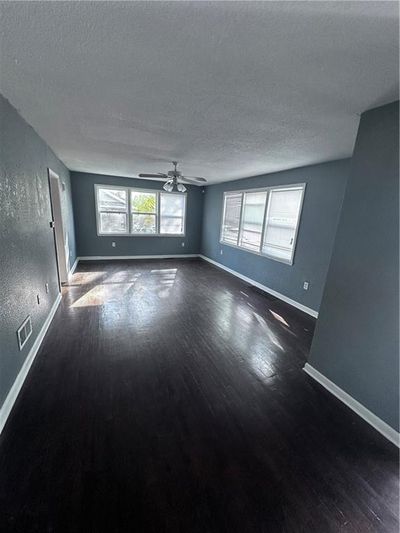 Unfurnished room featuring dark hardwood / wood-style floors, ceiling fan, and a textured ceiling | Image 3