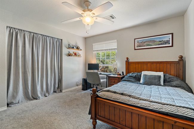 Carpeted bedroom featuring baseboards, ceiling fan, and visible vents | Image 31