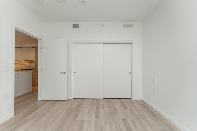 Unfurnished bedroom featuring a closet, light wood finished floors, and visible vents | Image 17