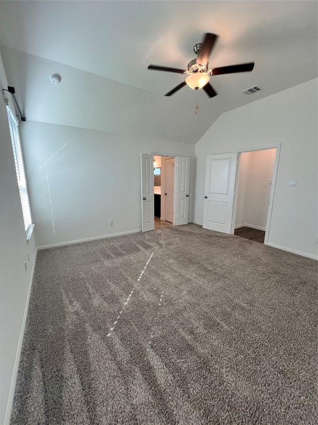Unfurnished bedroom featuring vaulted ceiling, carpet flooring, and ceiling fan | Image 30