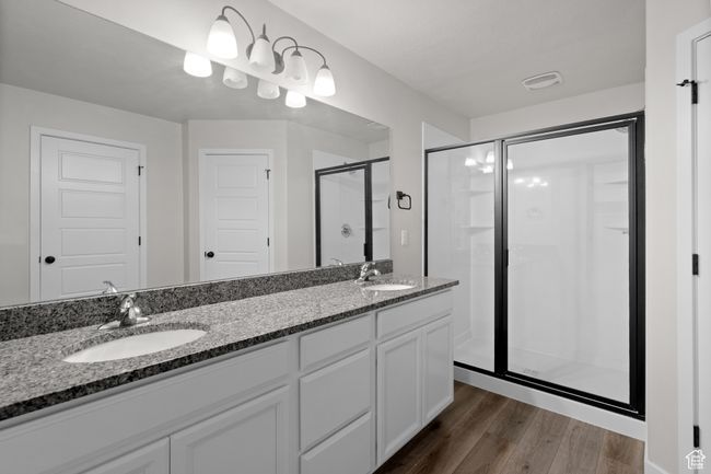 Bathroom with a shower stall, double vanity, and wood finished floors | Image 22