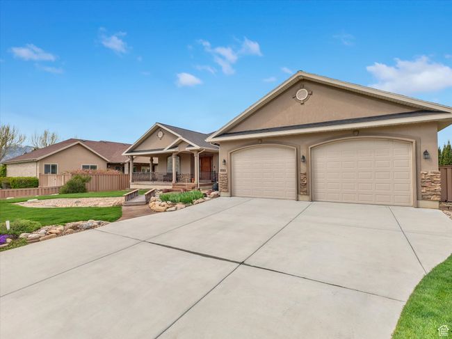 Single story home featuring a porch, concrete driveway, fence, a garage, and stucco siding | Image 41
