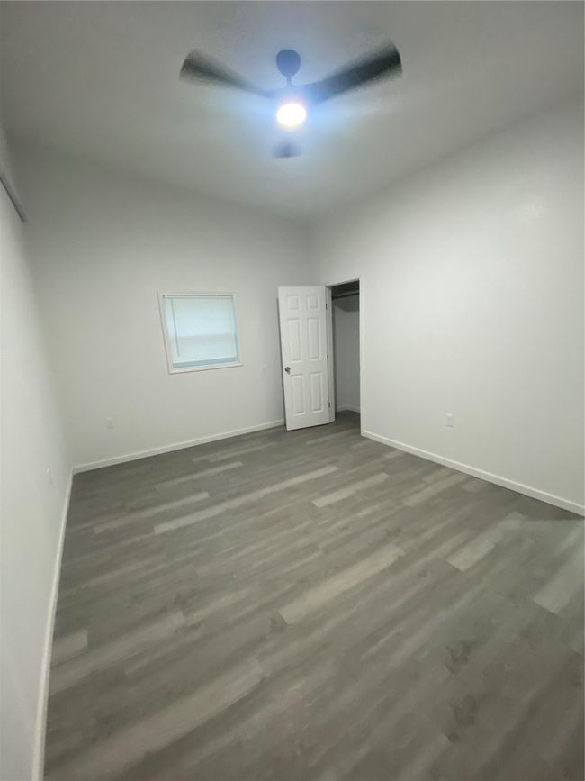 Unfurnished bedroom featuring baseboards, dark wood-style floors, and a ceiling fan | Image 9