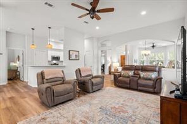 Living area featuring arched walkways, recessed lighting, ceiling fan, and wood finished floors | Image 6