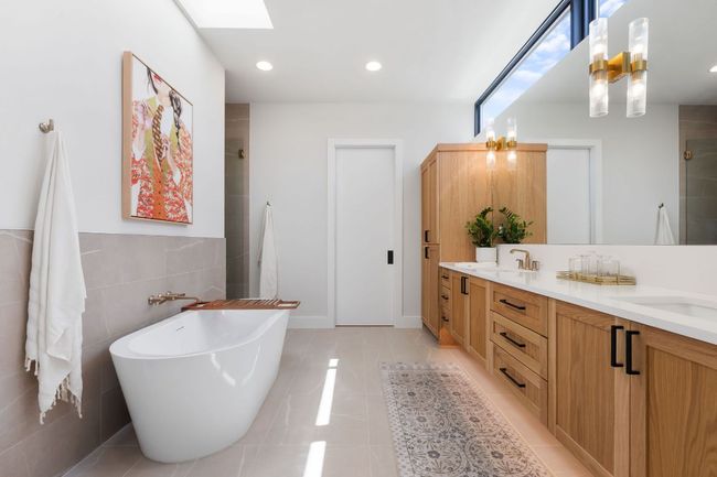 Bathroom with double vanity, tiled shower, a skylight, tile patterned floors, and a soaking tub | Image 27