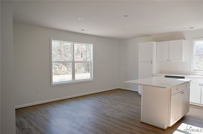 Kitchen featuring white cabinetry, plenty of natural light, and a center island | Image 6