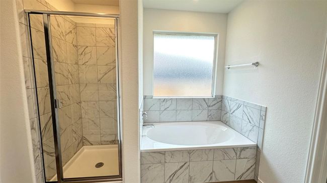 Bathroom with a textured wall, a shower stall, and a garden tub | Image 19