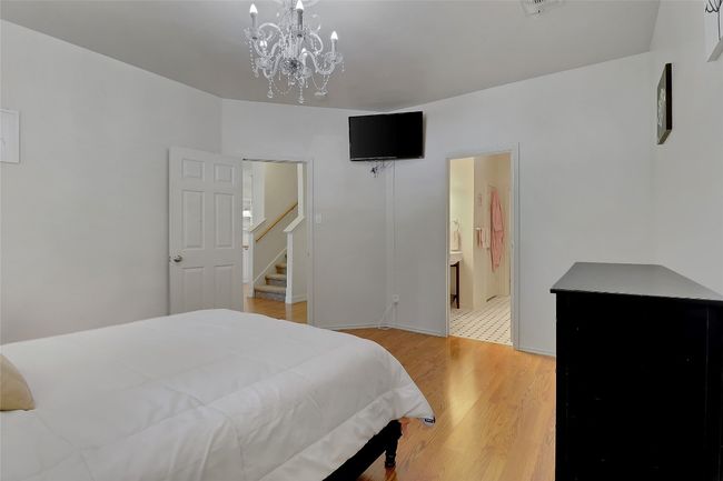 Bedroom featuring light wood finished floors, a chandelier, and ensuite bathroom | Image 14