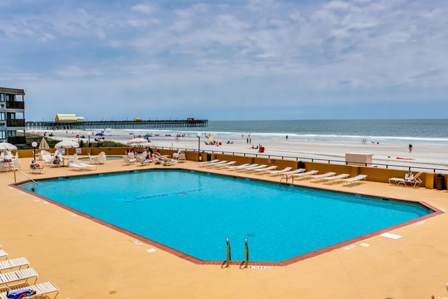 View of swimming pool with a view of the beach, a water view, and a patio area | Image 38