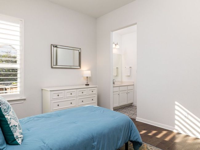 Bedroom with dark wood-type flooring, a sink, baseboards, and connected bathroom | Image 13