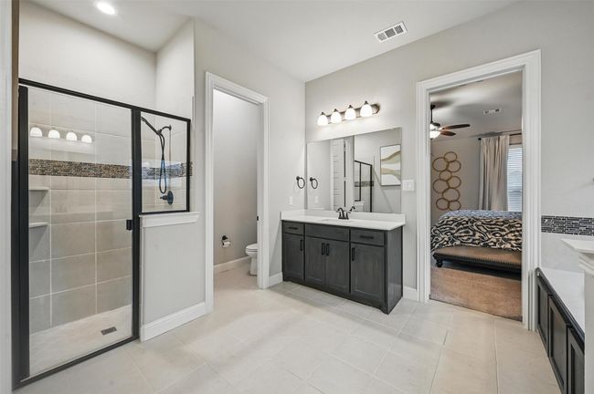 Ensuite bathroom with vanity, a shower stall, a ceiling fan, and tile patterned flooring | Image 24