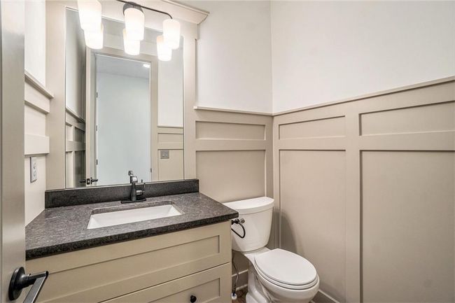 Half bath featuring vanity, toilet, and a decorative wall | Image 31