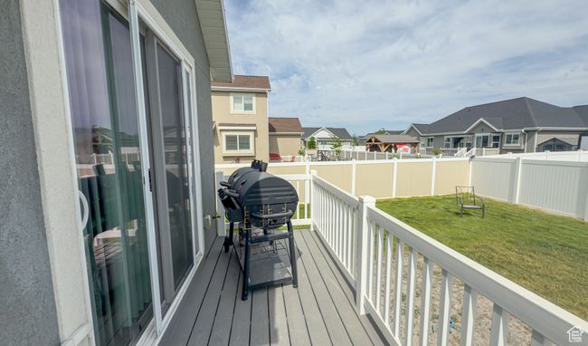 Wooden deck with a residential view, a grill, and a fenced backyard | Image 25