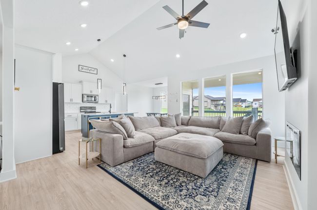 Living area with ceiling fan, light wood-style flooring, recessed lighting, and high vaulted ceiling | Image 6