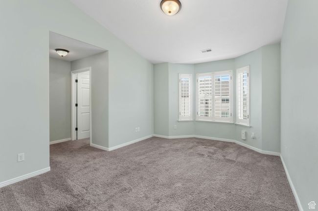 Empty room with baseboards, carpet floors, visible vents, and vaulted ceiling | Image 11