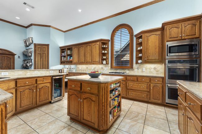 Kitchen featuring beverage cooler, open shelves, appliances with stainless steel finishes | Image 6