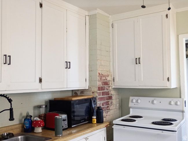 Kitchen featuring electric range, white cabinets and light countertops. | Image 30